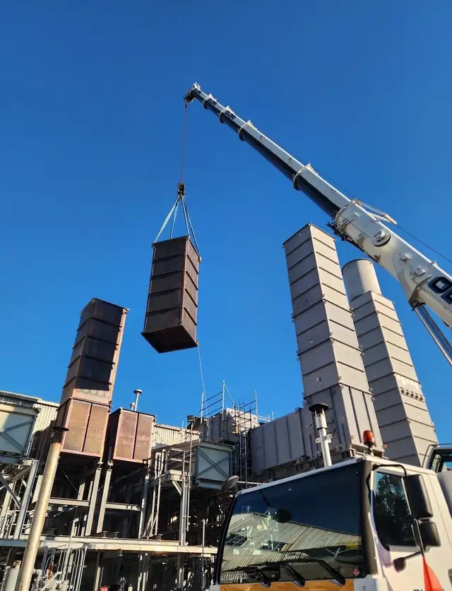 Crane hoisting a stack section into place