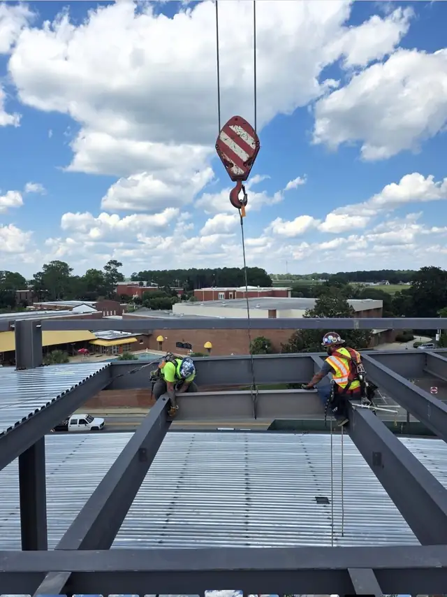 Ironworkers setting metal deck on a multi-story steel frame